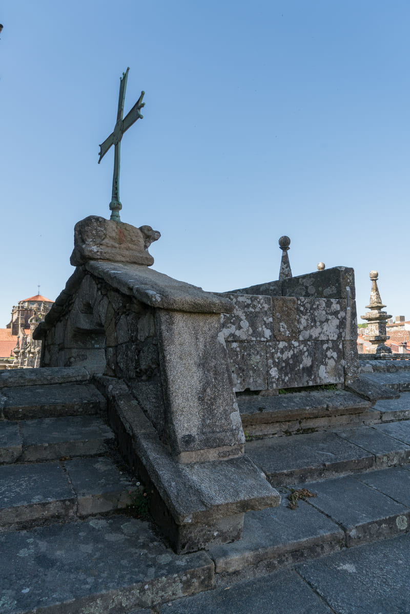 Cruz dos Farrapos en las cubiertas de la Catedral de Santiago, con el Cordero M&iacute;stico y la cruz de bronce sobre un murete con arco trilobulado