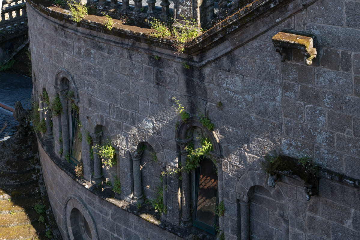 Muro exterior del crucero sur de la Catedral de Santiago, visto desde los tejados, con las ventanas rom&aacute;nicas tapiadas y un roset&oacute;n mateano sobre la fachada de Plater&iacute;as